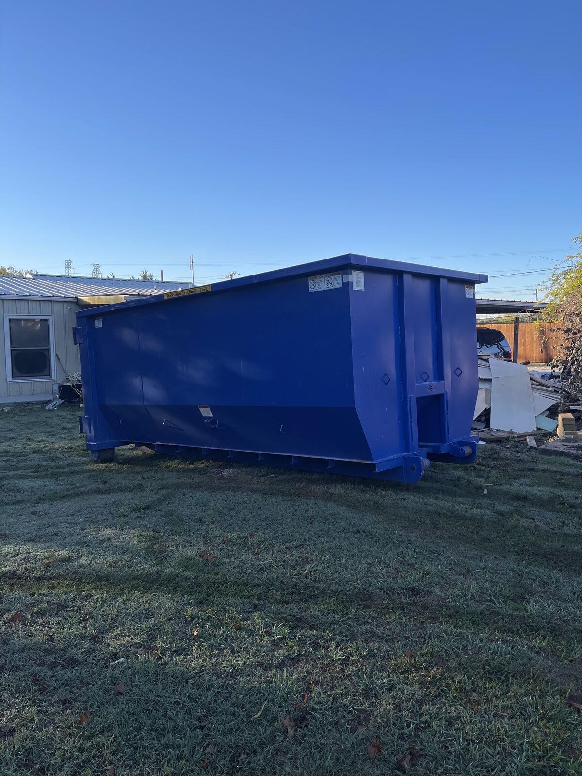 Blue 20 yard roll off dumpster delivered to a backyard in Rowlett TX