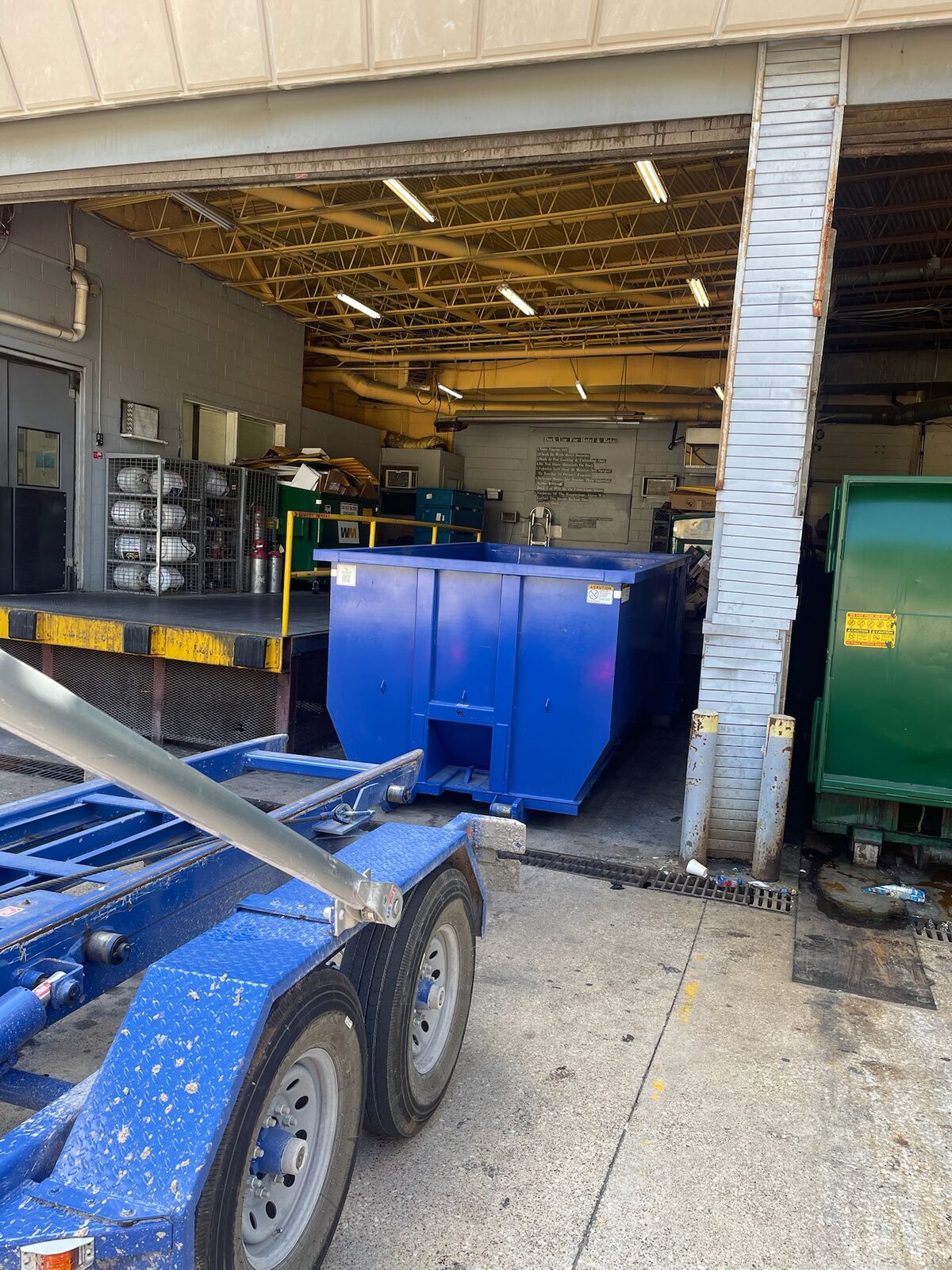Bluebonnet Roll Offs commercial dumpster pickup at a warehouse loading dock